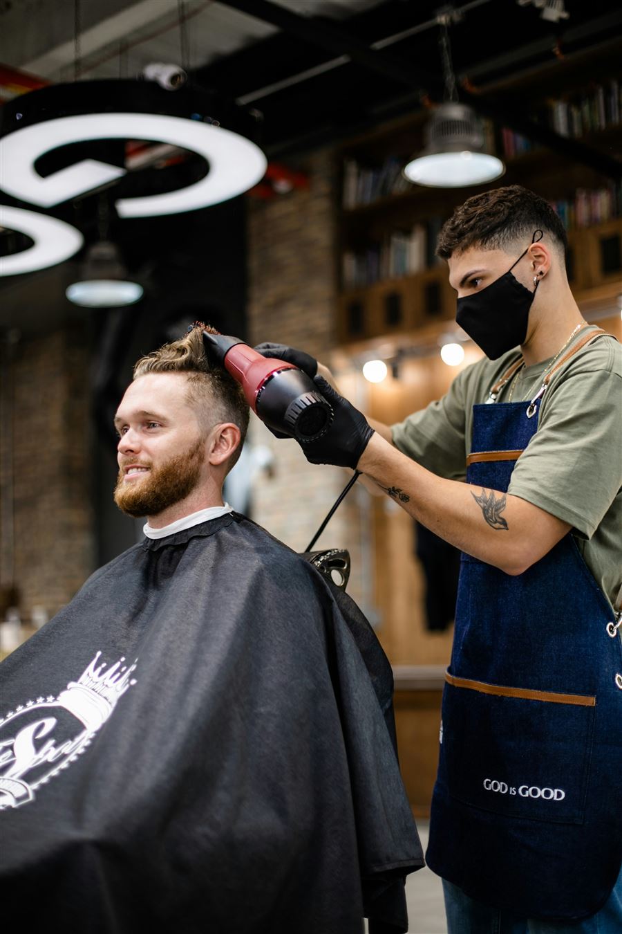 A barber cutting a client's hair in the chair