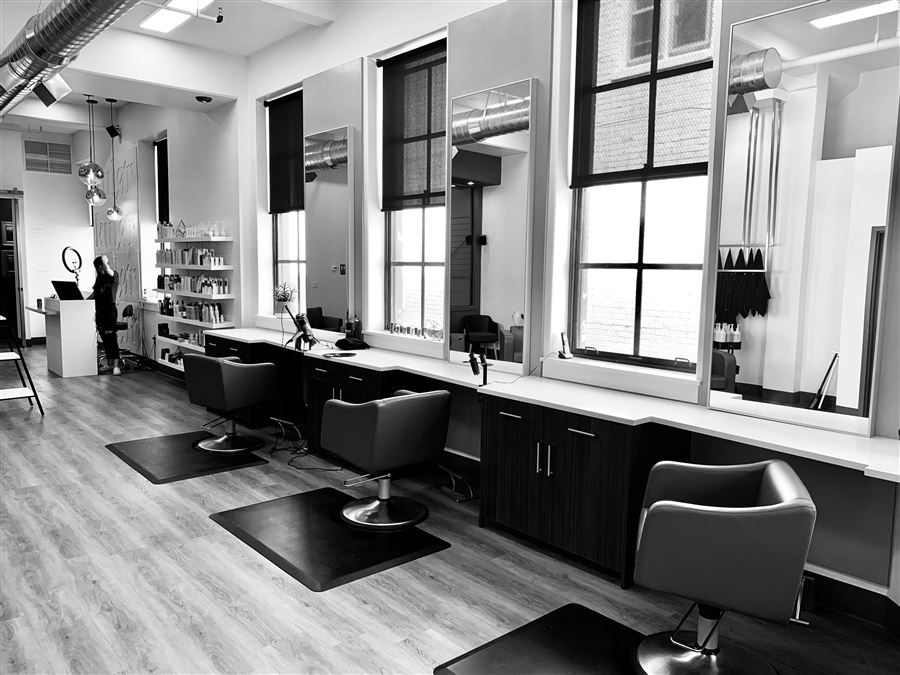 The shop floor with barber chairs and stations by the windows