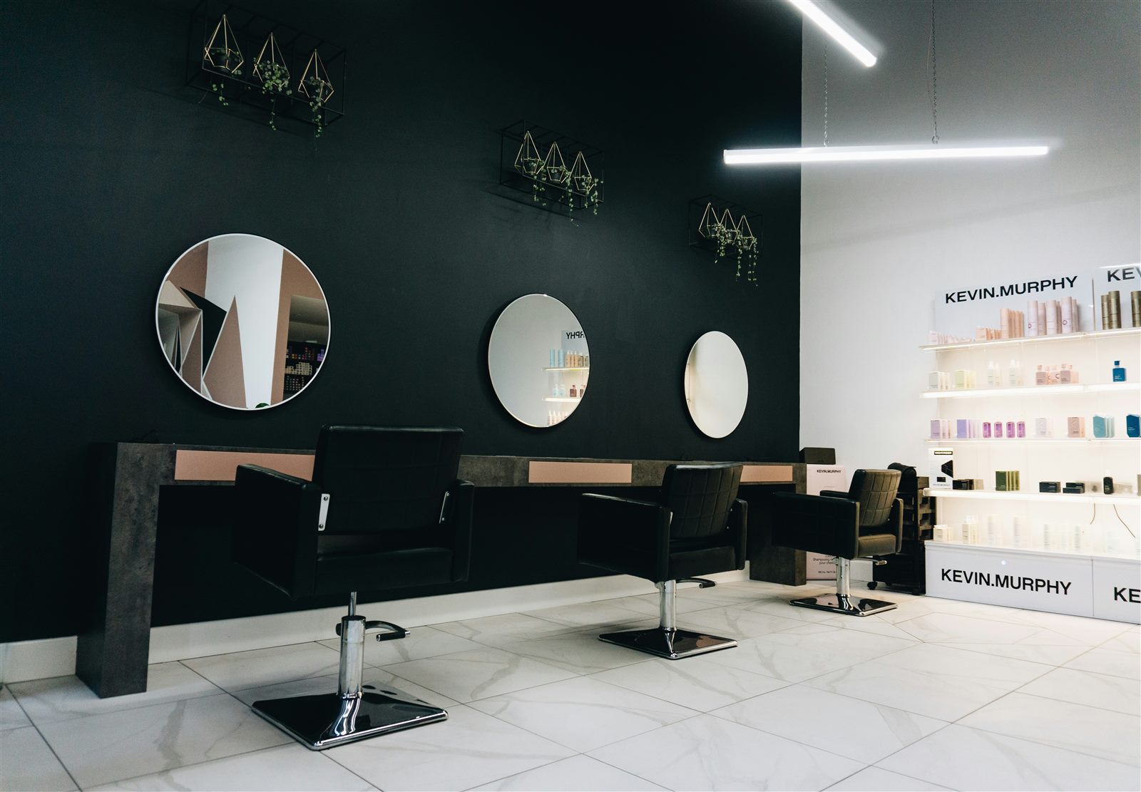 The clean, modern interior of the barbershop with mirrors and styling chairs