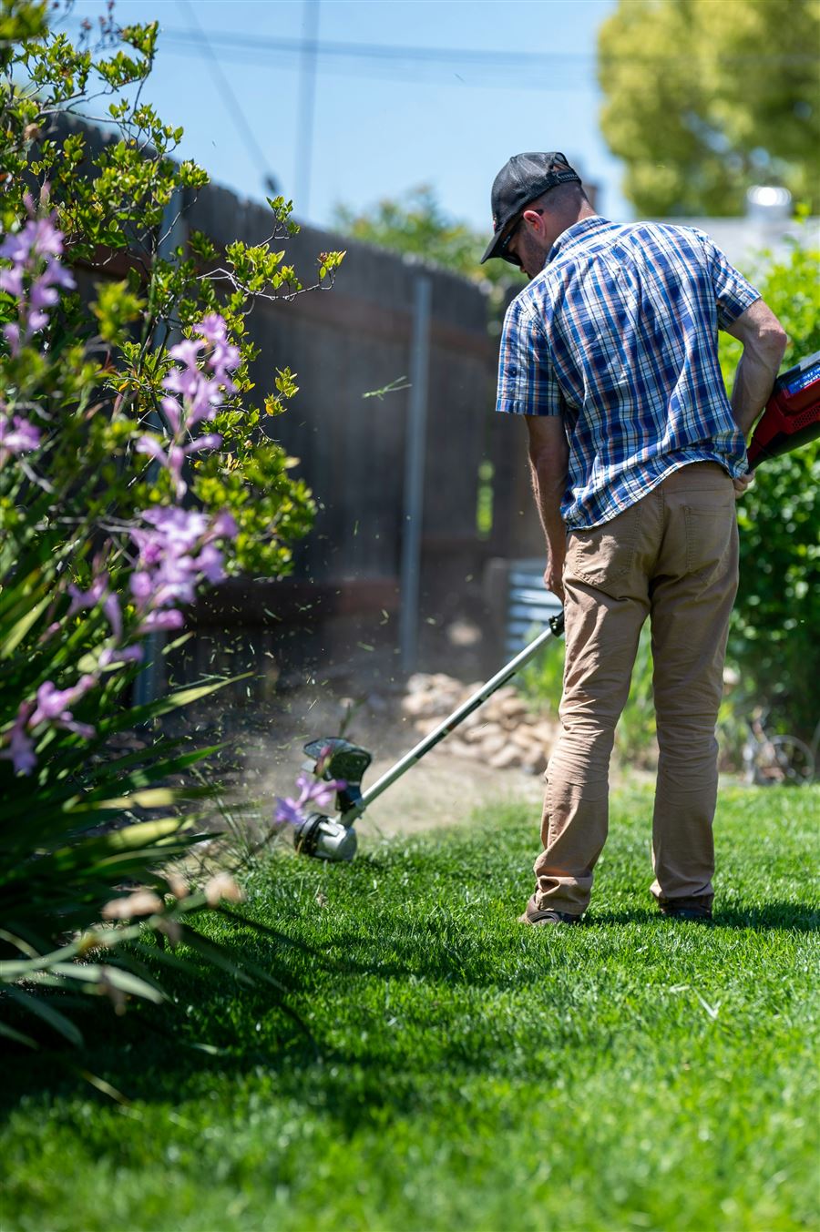 A crew member mowing a large lawn in clean stripes